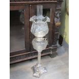 A Victorian silver plate oil lamp with shade, column base,