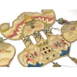 A selection of Oriental textiles including children's shoes, purse, and decorative adornments,