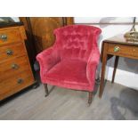A 19th Century velour covered button back armchair with turned legs to castors