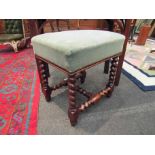 An 18th Century walnut stool on spiral supports and "H" stretcher with brass stud relief,