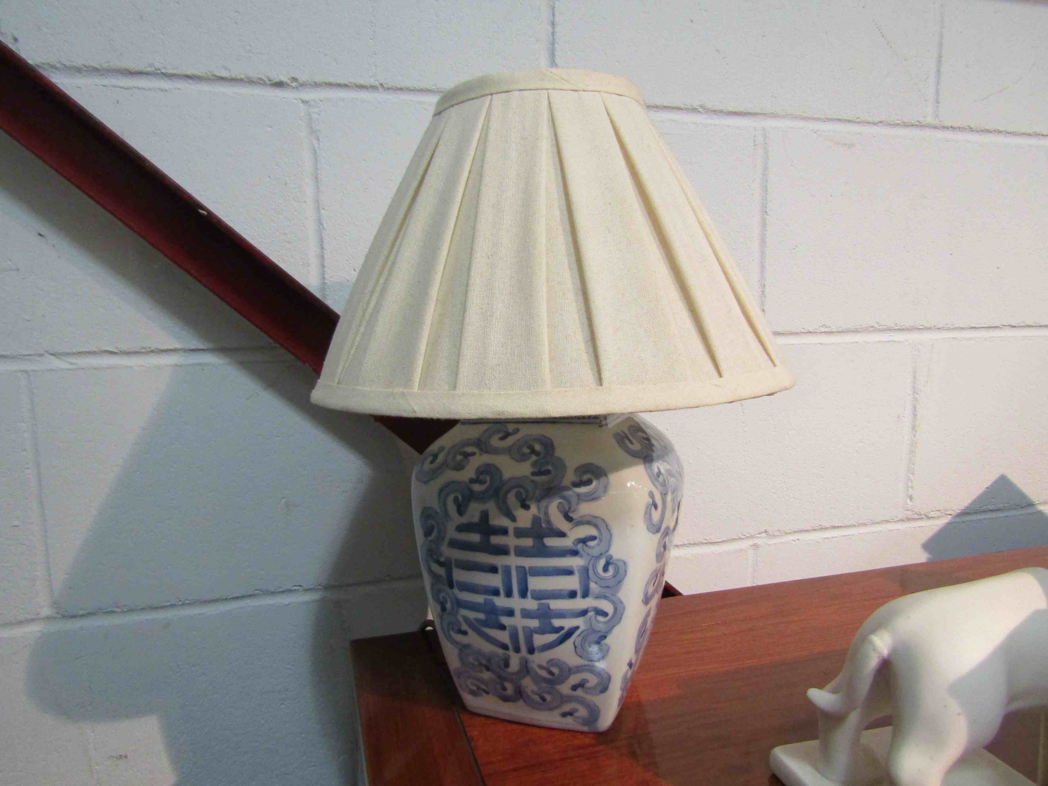 An Oriental blue and white floral design table lamp with pleated shade,