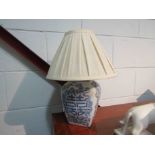 An Oriental blue and white floral design table lamp with pleated shade,