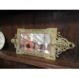 A Victorian pierced brass framed wall mirror with mask design,