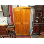 A two door pine and pine effect wardrobe,