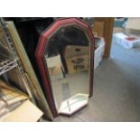 A bevel edged wall mirror with mirrored shelf