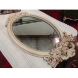 An oval wall mirror with hooks