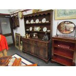 An 18th Century style oak dresser, plate rack above a three drawer, three cupboard door base,