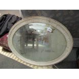 An oval wall hanging mirror
