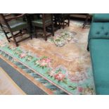 A large Chinese floral carpet in beige ground and mint green borders, tasselled fringe,