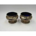 A pair of silver salts with blue glass liners