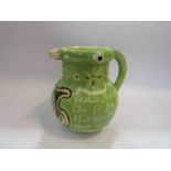 A puzzle jug signed by C.H. Brannam and dated 1899, decorated in pale green slip and initialled B.
