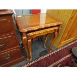 A nest of three wavy top tables on cabriole legs