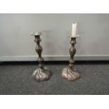 A pair of Sheffield plate candlesticks with scrolled relief,
