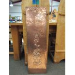 A copper wall hanging with floral decoration,