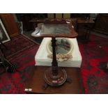 A Victorian mahogany music table with shaped and mirrored top on paw feet,