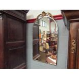 An arched top bevel edged mirror with shell and acanthus leaf crest,