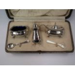 A silver cruet set comprising of salt, mustard, pepperette and one spoon,