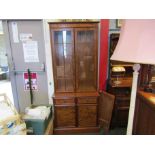 A walnut glazed cabinet on drawer and door base,