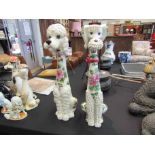 Two ceramic poodle figures with floral decoration,