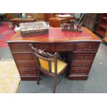 A George III style mahogany serpentine front twin pedestal desk of six drawers and cupboard door