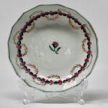 Late polychrome fluted saucer painted with a central pink flower and a circle of flower heads