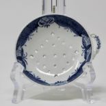 Blue & white egg drainer with piercings in a diamond shape and twisted handle with moulded flower