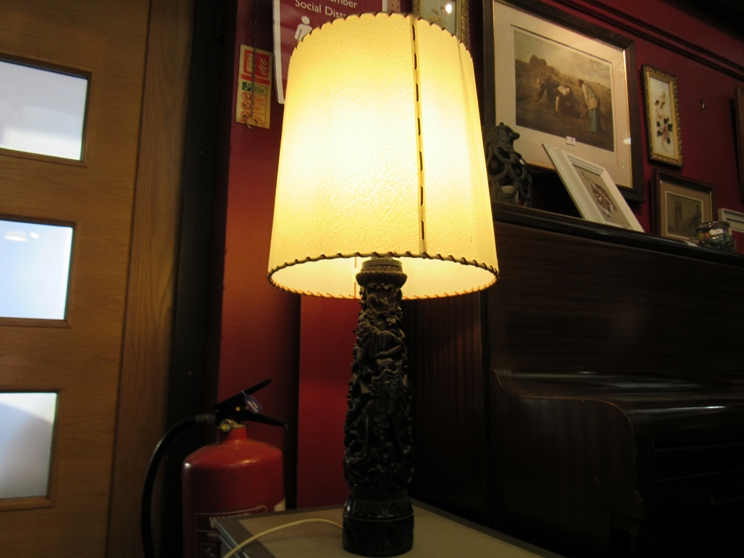 An Indian carved wood lamp base with shade