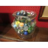 A glass jar containing a good quantity of marbles