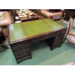 An eight drawer mahogany partners desk with gilt tooled leather top on bracket feet,