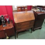 A 1930's oak bureau, fall front over twin drawers, shaped square legs,