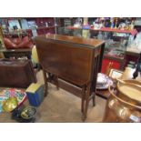 An Edwardian mahogany Sutherland table with decorative ends and satinwood line inlay