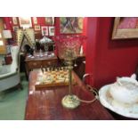 A Victorian brass oil lamp with cranberry tinted shade, converted to electric,