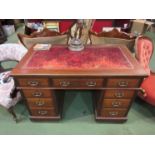 An Edwardian twin pedestal desk with worn leather top,