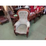 A Victorian walnut spoon back armchair with scroll carved decoration on turned tapering legs and