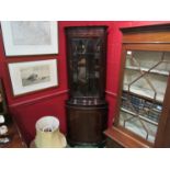 A reproduction mahogany corner cabinet