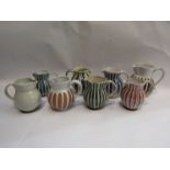 Eight 1950's Rye Pottery jugs with painted striped designs in various colours.