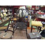 A 19th Century elm and oak wheel-back elbow chair the dished seat over turned legs joined by an 'H'