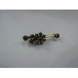 A gold bar brooch with old cut diamond set flower and diamond set terminals, 1ct total approx,