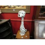 An Italian Pottery figure of a Dalmation wearing a red bow collar. Painted "Italy" to base.