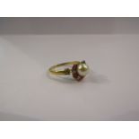 An 18ct ruby and diamond horseshoe ring mounted with central cultured pearl