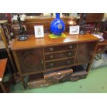 A 1930's Regency style mahogany sideboard, three central drawers, flanked by doors,