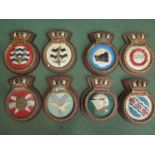 Eight family crest plaques on wooden mounts