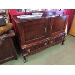 An early to mid 20th Century Dutch style sideboard with two doors over two drawers,