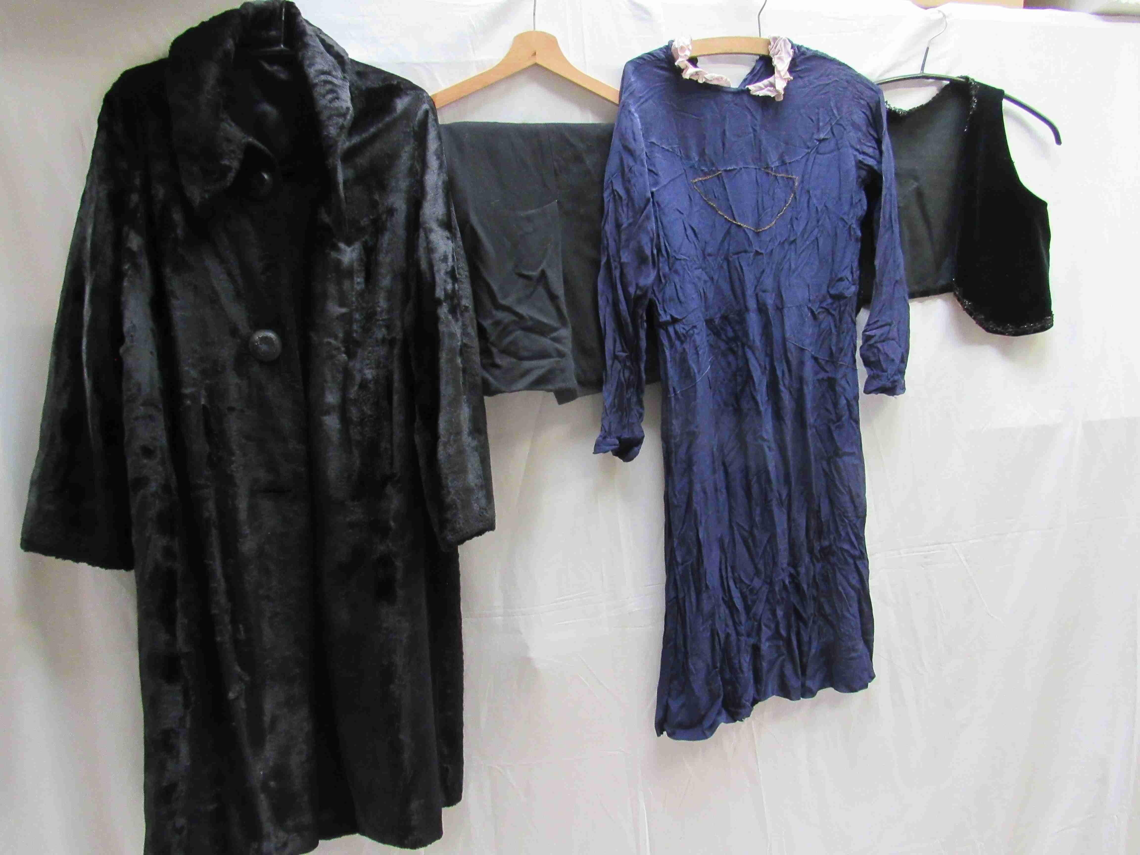 Four items of early 20th Century clothing, a black moleskin coat,