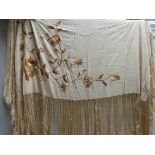 A cream silk shawl with fringing with embroidered golden flowers