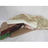 A small quantity of table linens, vintage fabric remnants, a bolt of lace,and a silk fringe shawl,