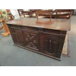 A Jacobean and later oak coffer with moulded and worked front panel,