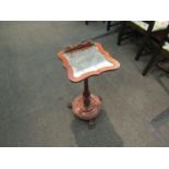 A Victorian mahogany music table with shaped and mirrored top on paw feet,