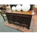 A 17th Century oak coffer, the rising lid over a carved three panel front on stile feet,