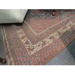A large Indian wool rug in blues and reds, worn,